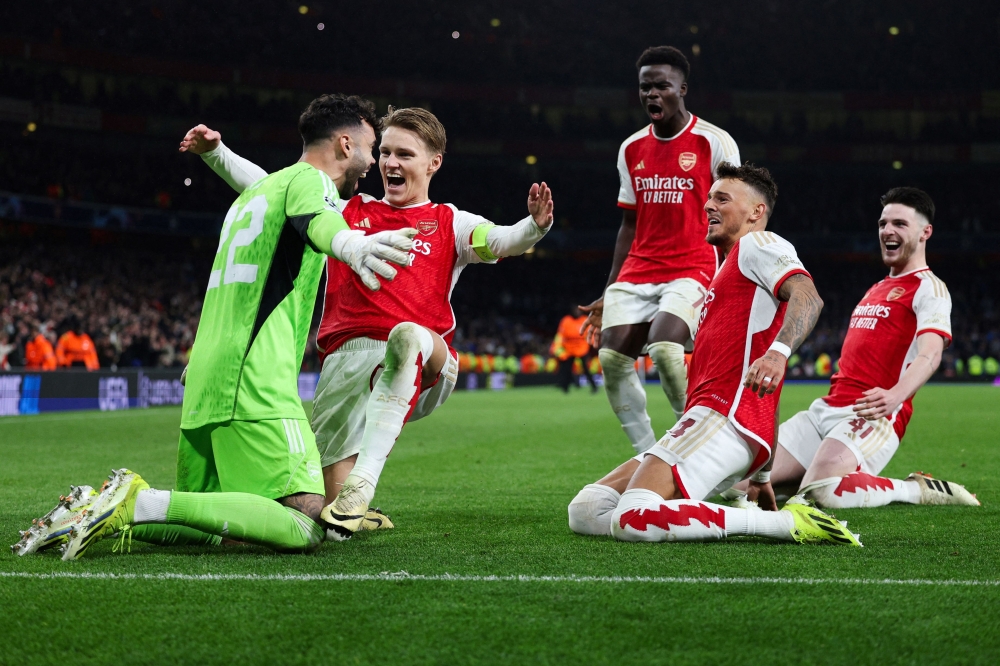(From L) Arsenal's Spanish goalkeeper #22 David Raya, Arsenal's Norwegian midfielder #08 Martin Odegaard, Arsenal's English midfielder #07 Bukayo Saka, Arsenal's English defender #04 Ben White and Arsenal's English midfielder #41 Declan Rice celebrate after winning the penalty shoot-out session the UEFA Champions League last 16 second leg football match between Arsenal and Porto FC at the Arsenal Stadium in north London, on March 12, 2024. (Photo by Adrian DENNIS / AFP)
