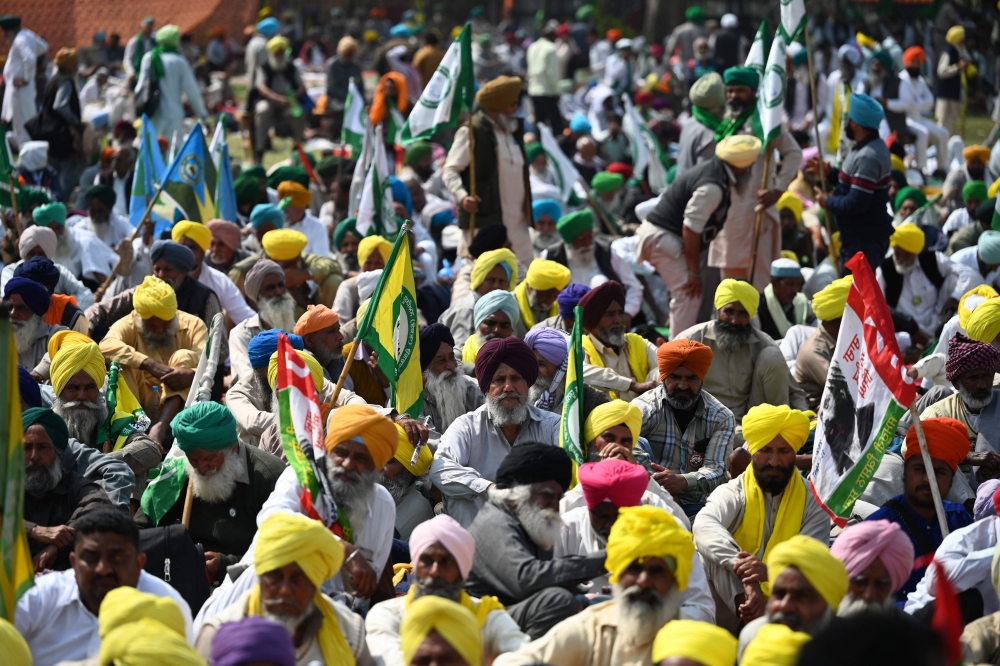 Farmers take part in a sit-in protest demanding minimum crop prices, loan waivers and an investigation into the death of a farmer during the farmers' protest 