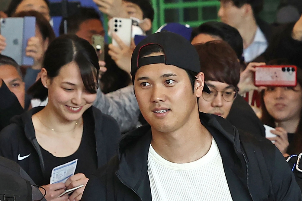Los Angeles Dodgers Shohei Ohtani (C) arrives with his wife Mamiko Tanaka (L) and his team's players at Incheon International Airport in Incheon on March 15, 2024, ahead of the 2024 MLB Seoul Series baseball games between Los Angeles Dodgers and San Diego Padres. (Photo by YONHAP / AFP)