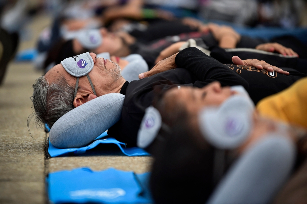 People enjoy a nap while attending the World Sleep Day event at the Monumento a la Revoluciَn in Mexico City, Mexico, on March 15, 2024. (Photo by Rodrigo Oropeza / AFP)