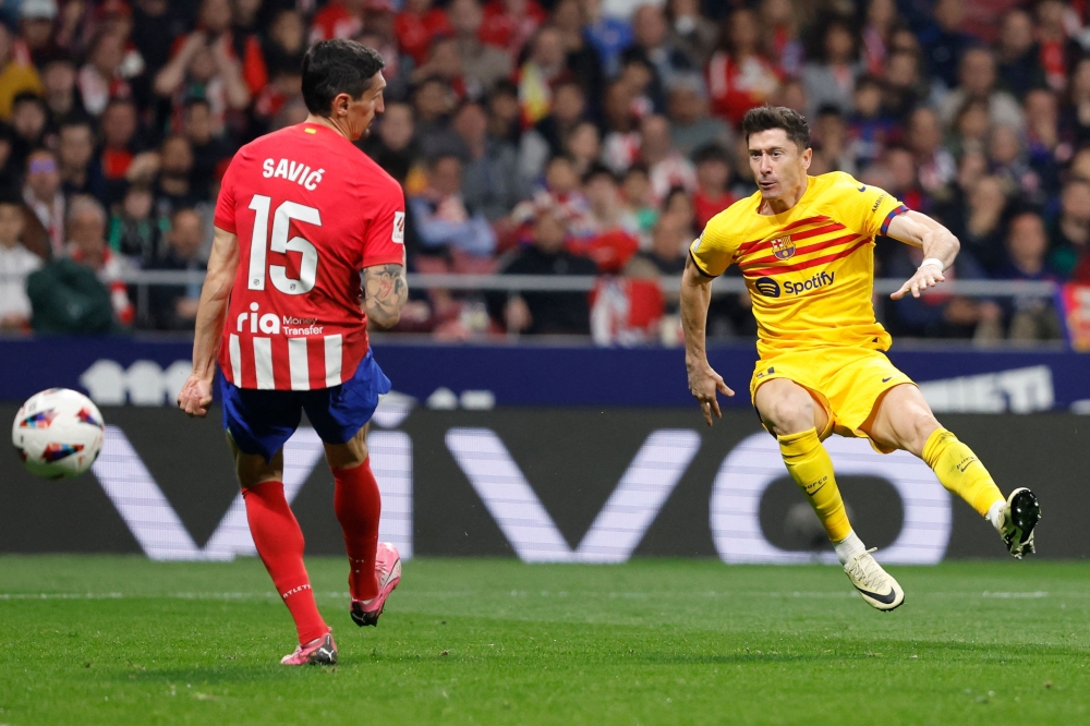 Barcelona's Polish forward #09 Robert Lewandowski scores his team's second goal during the Spanish league football match between Club Atletico de Madrid and FC Barcelona at the Metropolitano stadium in Madrid on March 17, 2024. (Photo by OSCAR DEL POZO / AFP)
