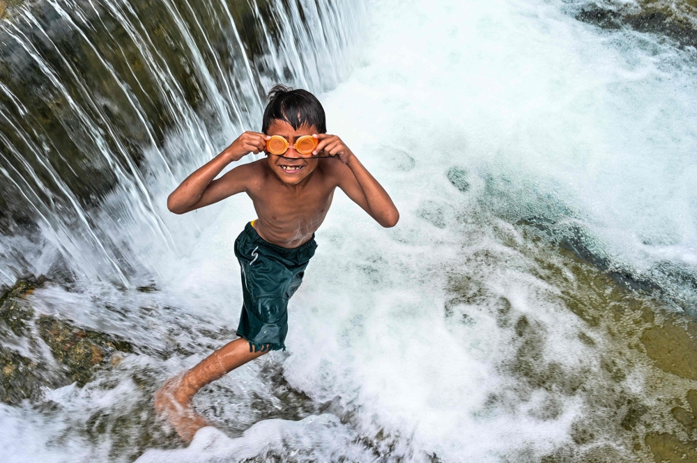 A child puts his swimming goggles on before jumping in a public pool of spring water in Japakeh, Indonesia's Aceh province on March 22, 2024, during the World Water Day. (Photo by Chaideer Mahyuddin / AFP)