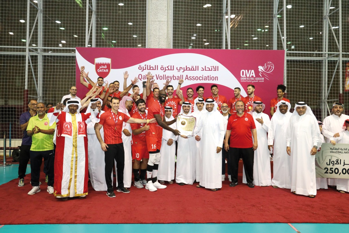 Al Arabi players and officials celebrate as they receive the champions' trophy.