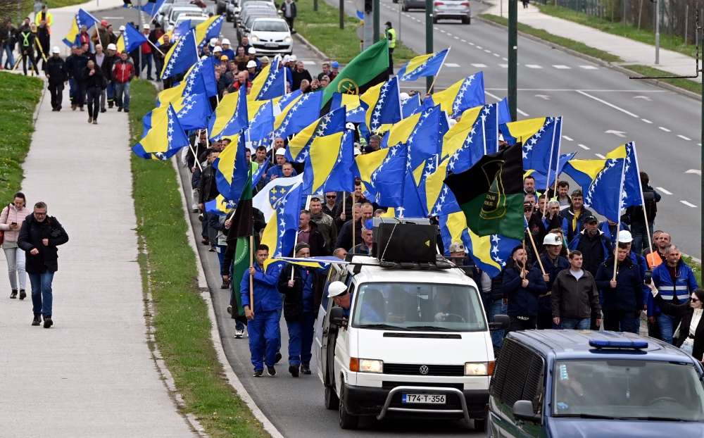 Bosnian coal miners wave Bosnian flags as they march towards government building in Sarajevo, on March 27, 2024, to protest against the deterioration of their working conditions. (Photo by ELVIS BARUKCIC / AFP)

