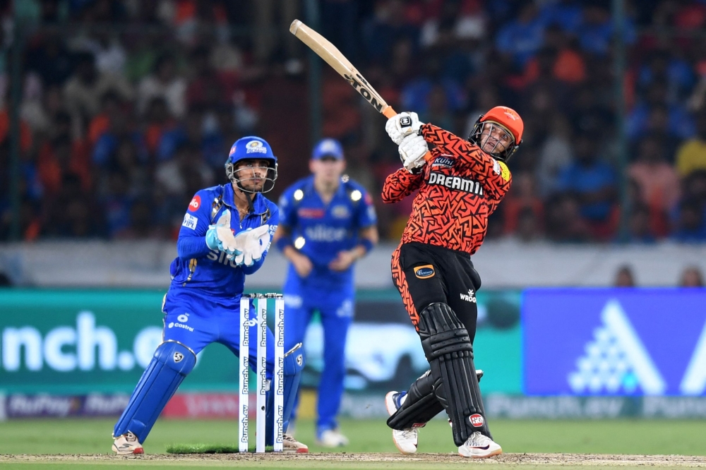 Sunrisers Hyderabad's Abhishek Sharma (R) plays a shot as Mumbai Indians' wicketkeeper Ishan Kishan fields during the Indian Premier League (IPL) Twenty20 cricket match between Sunrisers Hyderabad and Mumbai Indians at the Rajiv Gandhi International Stadium in Hyderabad on March 27, 2024. (Photo by Noah SEELAM / AFP)
