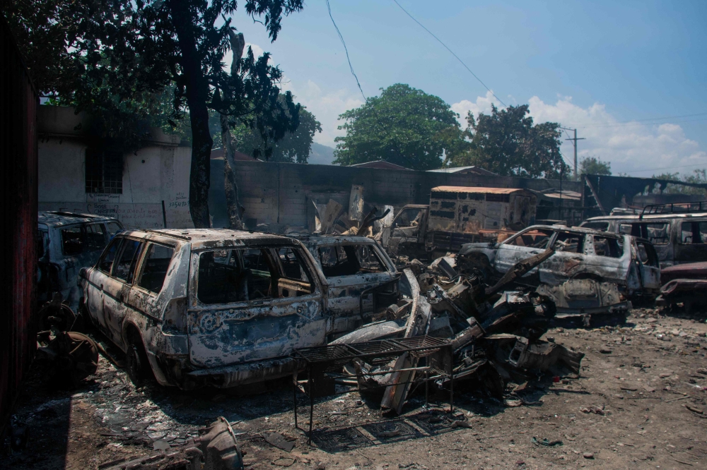 The charred remains of vehicles that were burned near a garage are seen in Port-au-Prince, Haiti, on March 25, 2024. (Photo by Clarens SIFFROY / AFP)
