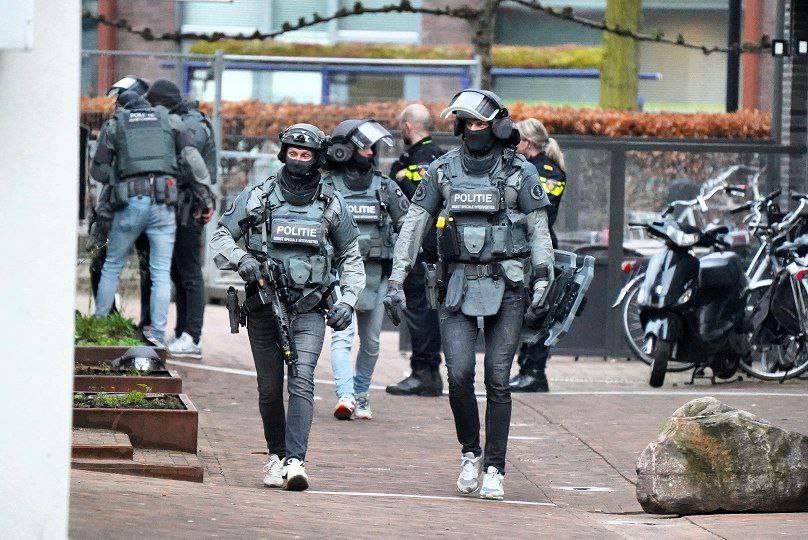Members of the DSI special police forces patrol outside a cafe where several people are taken hostages in Ede, on March 30, 2024. (Photo by Remko de Waal / ANP / AFP)