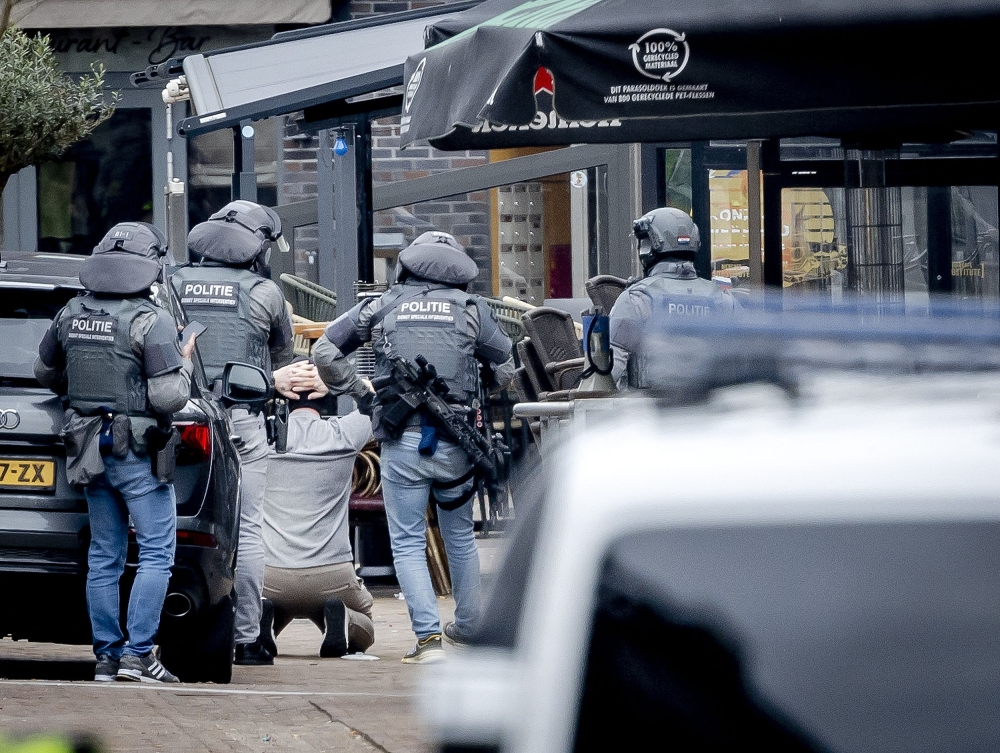 A man is arrested by members of the DSI special police forces in a cafe in Ede, on March 30, 2024. (Photo by Remko de Waal / ANP / AFP) 