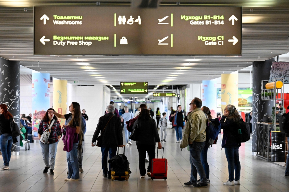 Passengers walk in the departure area of Sofia Airport after Bulgaria's official partial entry (air and sea) into the Europe's open-borders Schengen area on March 31, 2024. Photo by Nikolay DOYCHINOV / AFP. 