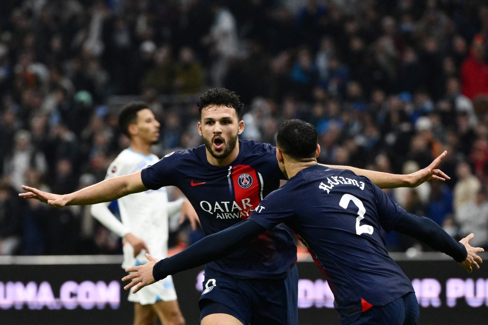 Paris Saint-Germain's Portuguese forward #09 Goncalo Ramos (L) celebrates with Paris Saint-Germain's Moroccan defender #02 Achraf Hakimi after scoring his team's second goal during the French L1 football match between Olympique Marseille (OM) and Paris Saint-Germain (PSG) at Stade Velodrome in Marseille, southeastern France, on March 31, 2024. (Photo by CHRISTOPHE SIMON / AFP)
