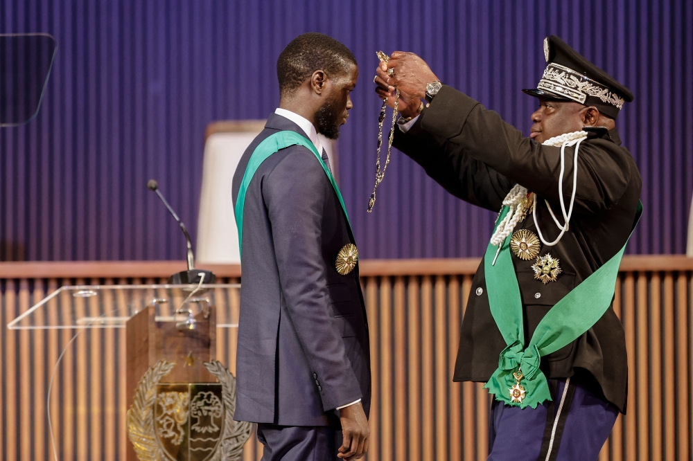 Bassirou Diomaye Faye (L) is sworn in as Senegal's President at an exhibition centre in the new town of Diamniadio near the capital Dakar on April 2, 2024. Photo by John WESSELS / AFP. 