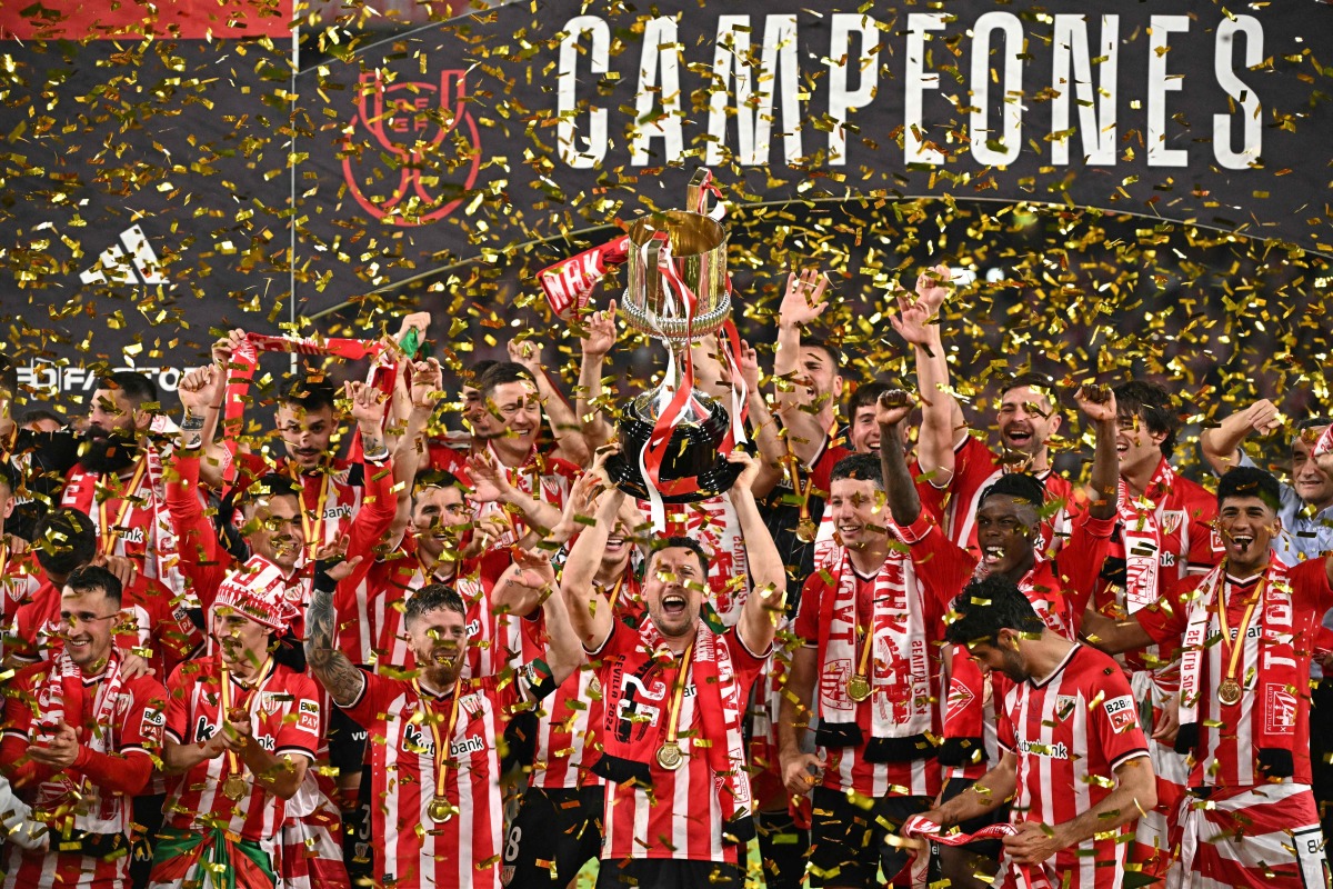 Athletic Bilbao's players celebrate victory with their Copa del Rey trophy at the end of the Spanish Copa del Rey (King's Cup) final football match between Athletic Club Bilbao and RCD Mallorca at La Cartuja stadium in Seville on April 6, 2024. (Photo by JAVIER SORIANO / AFP)