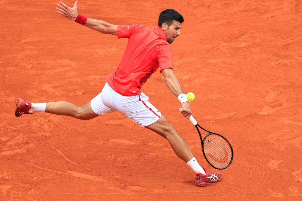 Serbia's Novak Djokovic plays a backhand return to Russia's Roman Safiullin during their Monte Carlo ATP Masters Series Tournament round of 32 tennis match on the Rainier III court at the Monte Carlo Country Club on April 9, 2024. (Photo by Valery HACHE / AFP)