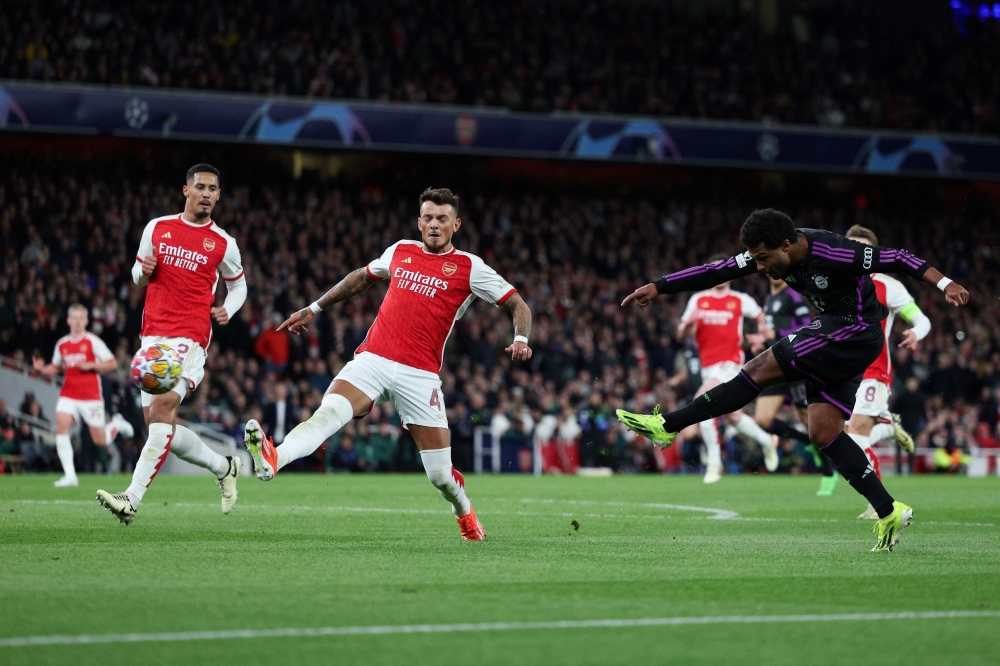 Bayern Munich's German midfielder #07 Serge Gnabry (R) shoots the ball during the UEFA Champions League quarter final first-leg football match between Arsenal and Bayern Munich at the Arsenal Stadium, in north London, on April 9, 2024. (Photo by Adrian DENNIS / AFP)