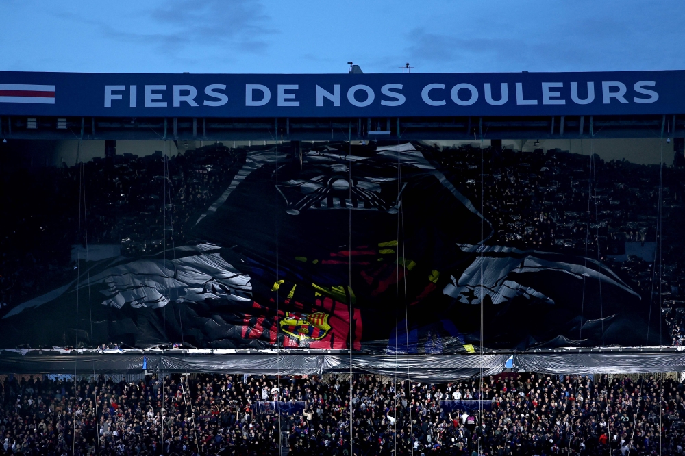 Barcelona's supporters unveil a giant banner with a depiction of the Star Wars Darth Vader wearing a Barcelona shirt in the stands ahead of the UEFA Champions League quarter final first leg football match between Paris Saint-Germain (PSG) and FC Barcelona at the Parc des Princes stadium in Paris on April 10, 2024. (Photo by Anne-Christine Poujoulat / AFP)
