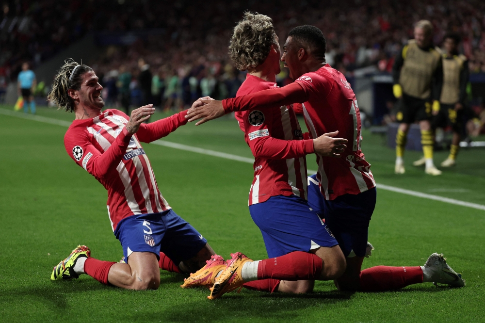 Atletico Madrid's Brazilian forward #12 Samuel Lino (right) celebrates with teammates after scoring his team's second goal during the UEFA Champions League quarter final first leg football match between Club Atletico de Madrid and Borussia Dortmund at the Metropolitano stadium in Madrid on April 10, 2024. (Photo by Thomas Coex / AFP)