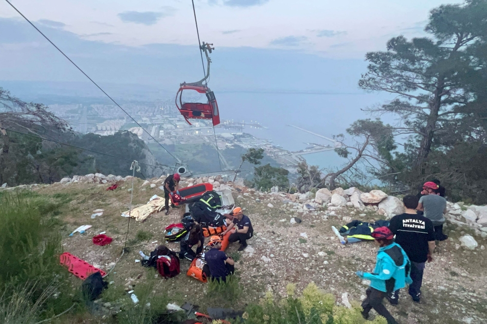 Photograph taken and released on April 12, 2024 by Turkish news agency DHA (Demiroren News Agency) shows rescue teams conducting a rescue operation and helping injured people after a cable car cabin crashed into a fallen cable pole in Konyaalti district of Antalya. Photo by Handout / DHA (Demiroren News Agency) / AFP. 