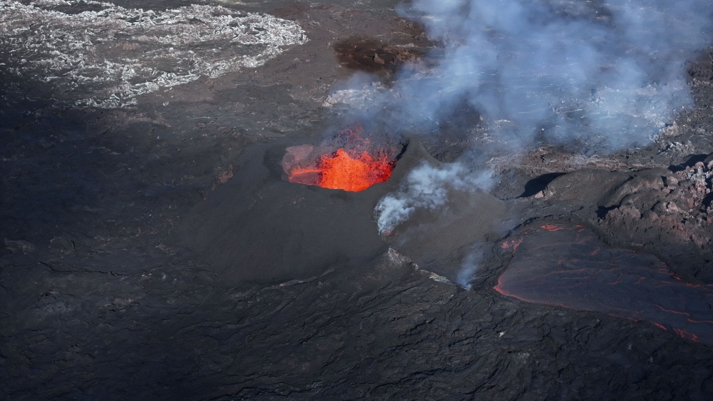 Picture taken with a drone on April 13, 2024 at Svartsengi near Grindavik, Iceland, shows an aerial view of a volcanic eruption at Sundhnukagigar in southwest Iceland, ongoing for a month. (Photo by Jeremie Richard / AFP) 