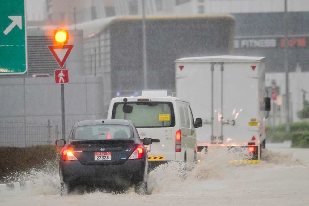 Vehicles drive on a flooded road during torrential rain in the Gulf Emirate of Dubai on April 16, 2024. Photo by Giuseppe CACACE / AFP