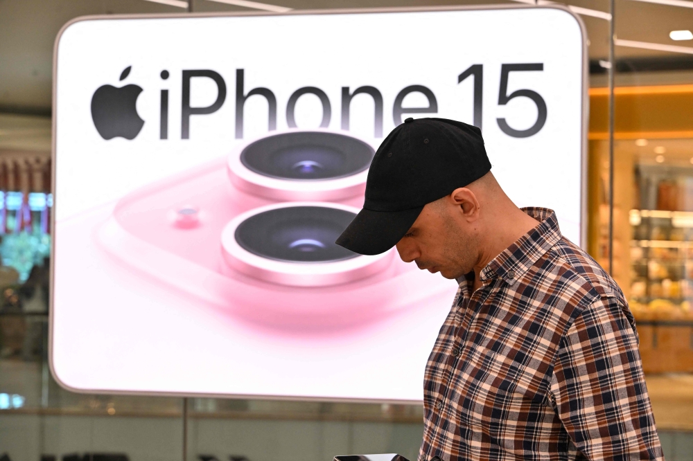 A man checks an Apple product at an Apple reseller store iBox in Jakarta on April 17, 2024. Photo by Adek BERRY / AFP