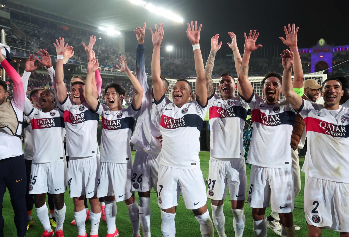 Paris Saint-Germain's French forward #07 Kylian Mbappe (C) and teammates celebrate after winning the UEFA Champions League quarter-final second leg football match between FC Barcelona and Paris SG at the Estadi Olimpic Lluis Companys in Barcelona on April 16, 2024. (Photo by Franck FIFE / AFP)
