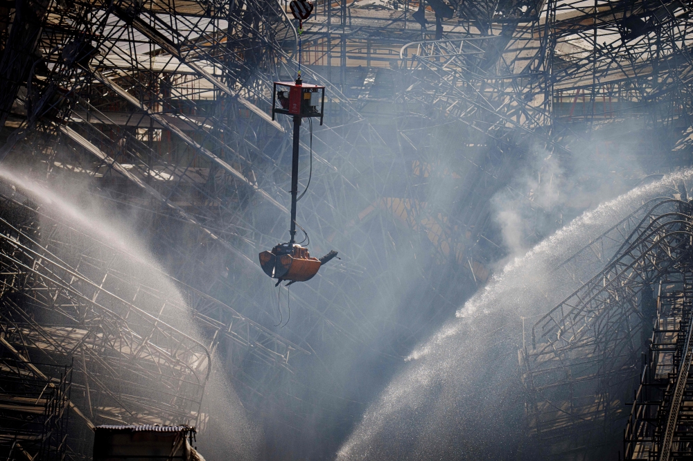 View taken from the tower of the Parliament as Danish firefighters and emergency personnel work on the structure during the final extinguishing operations one day after a fire ravaged the historic Boersen Stock Exchange and toppled its iconic spire in Copenhagen on April 17, 2024. Photo by Liselotte Sabroe / Ritzau Scanpix / AFP

