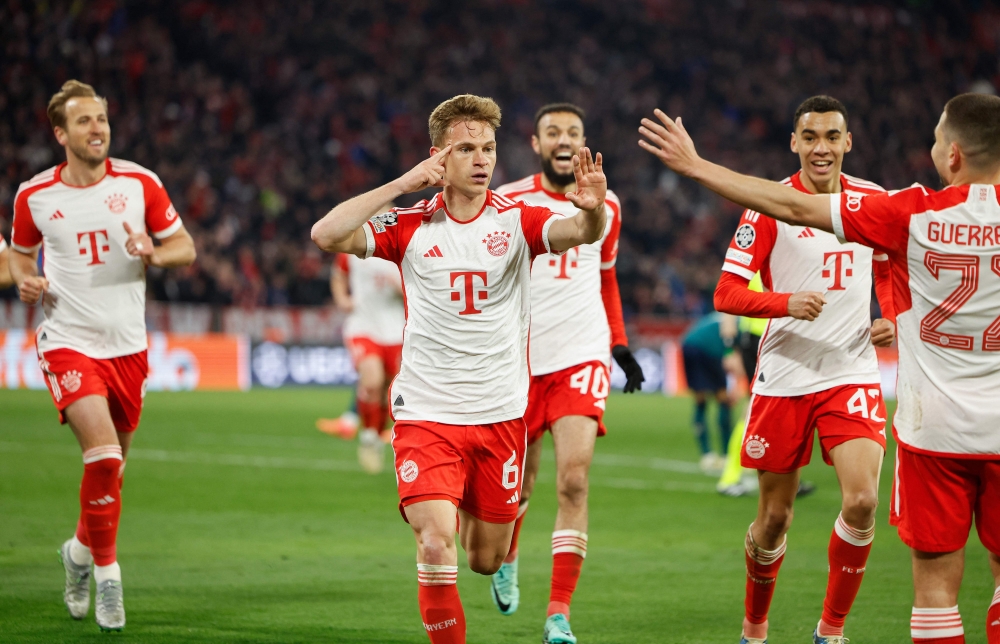 Bayern Munich's German midfielder #06 Joshua Kimmich (center) celebrates scoring the opening goal with his teammates during the UEFA Champions League quarter-final second leg football match between FC Bayern Munich and Arsenal FC in Munich, southern Germany on April 17, 2024. (Photo by Odd Andersen / AFP)