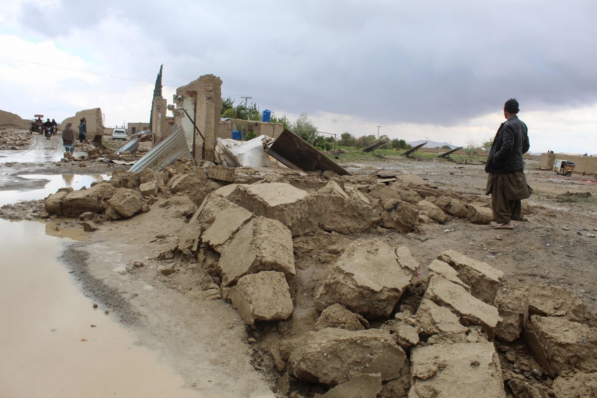 Residents gather beside a damaged house after heavy rains on the outskirts of Chaman in Balochistan province on April 19, 2024. At least 65 people have died in storm-related incidents including lightning in Pakistan, officials said, with rain so far in April falling at nearly twice the historical average rate. (Photo by Abdul BASIT / AFP