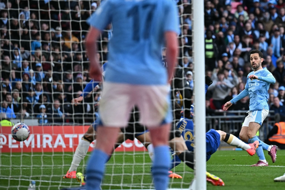 Manchester City's Portuguese midfielder #20 Bernardo Silva (R) scores the opening goal of the English FA Cup semi-final football match between Manchester City and Chelsea at Wembley Stadium in north west London on April 20, 2024. (Photo by Ben Stansall / AFP) 