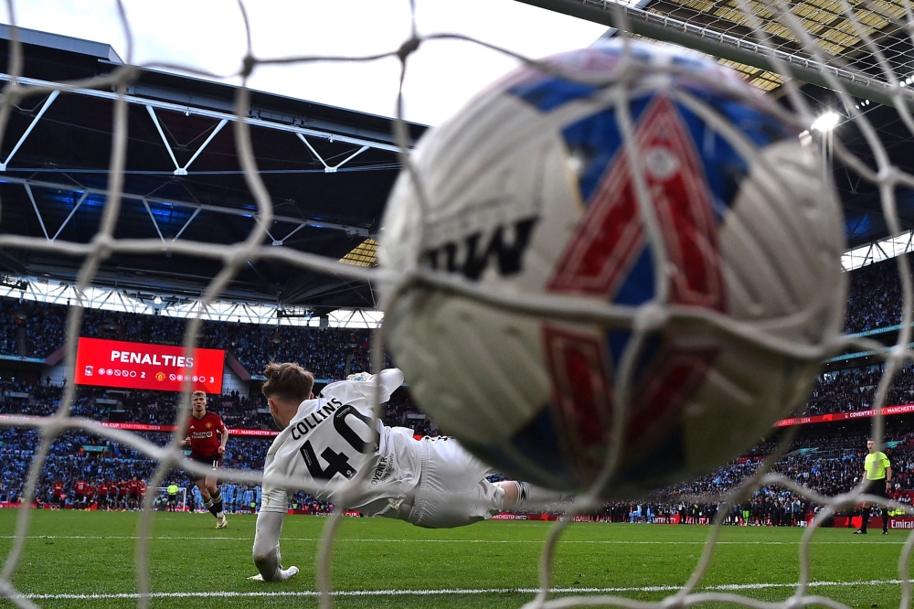 Manchester United's Danish striker #11 Rasmus Hojlund (L) scores the winning penalty in the shoot-out during the English FA Cup semi-final football match between Coventry City and Manchester United at Wembley Stadium in north west London on April 21, 2024. (Photo by Glyn KIRK / AFP) 

