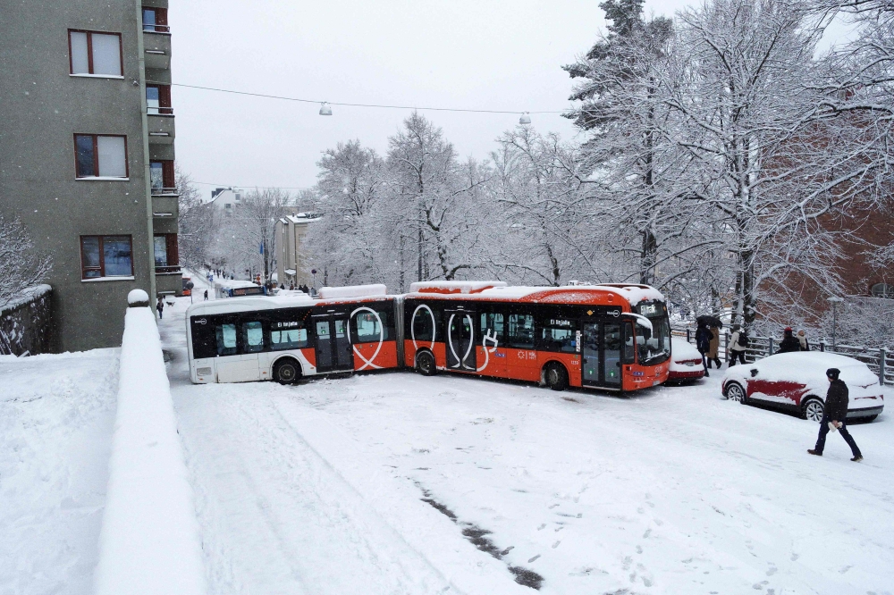 A bus blocks a street during a snowy spring day in Helsinki, Finland, on April 23, 2024. Photo by Teemu Salonen / Lehtikuva / AFP