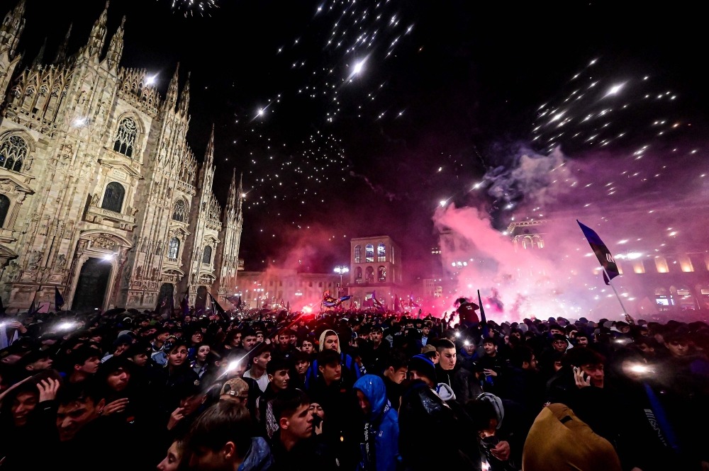 Inter Milan's supporters celebrate by the Duomo in central Milan after they won the 2024 Scudetto championship title on April 22, 2024, following the Italian Serie A football match between AC Milan and Inter Milan at the San Siro Stadium in Milan. (Photo by Piero CRUCIATTI / AFP)
