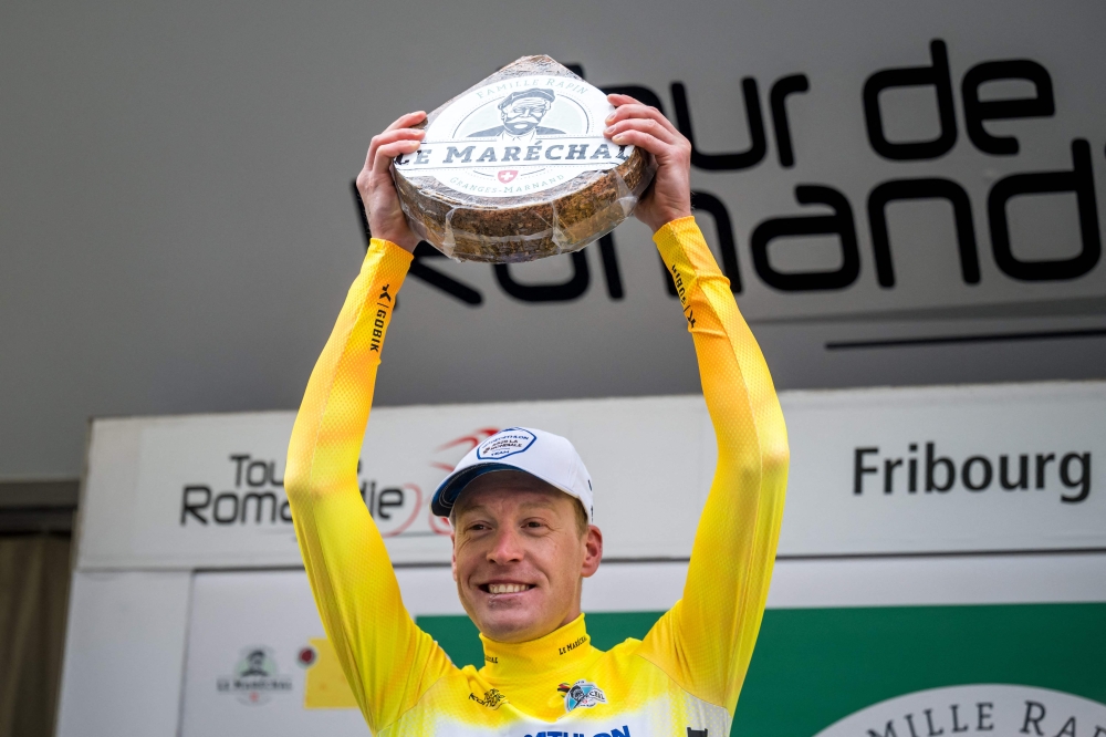 French cyclist Dorian Godon of the Decathlon AG2R La Mondiale Team, winner of the stage and wearing the overall leader's yellow jersey, smiles during the podium ceremony of the first stage of the Tour of Romandy UCI cycling World tour 165,7 km from Chateau d'Oex to Fribourg, on April 24, 2024. (Photo by Fabrice COFFRINI / AFP)
