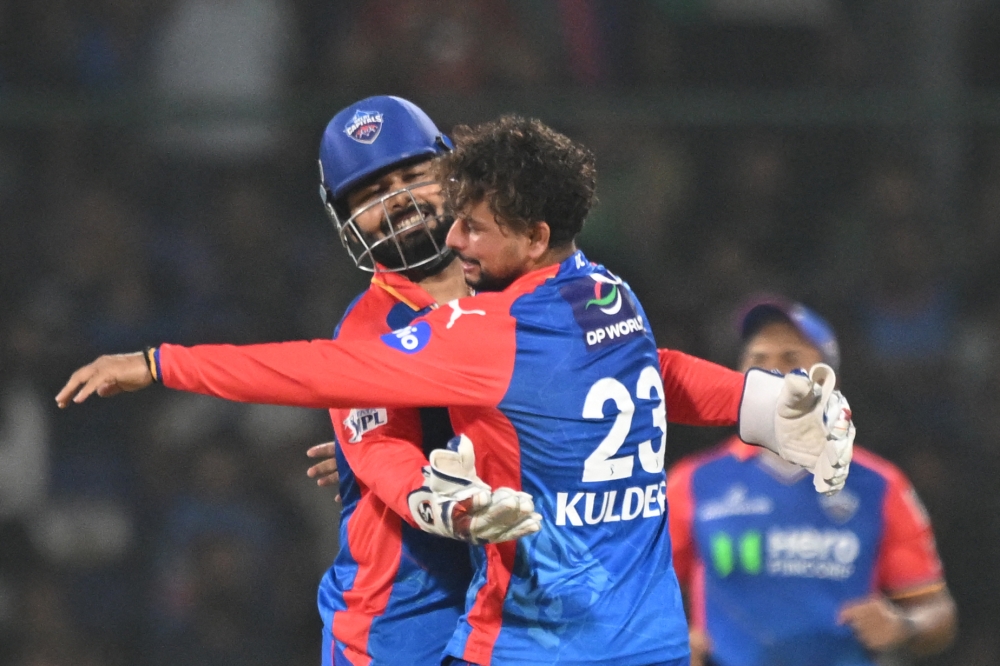 Delhi Capitals' Kuldeep Yadav (R) celebrates with captain Rishabh Pant after taking the wicket of Gujarat Titans' Rahul Tewatia during the Indian Premier League (IPL) Twenty20 cricket match between Delhi Capitals and Gujarat Titans at the Arun Jaitley Stadium in New Delhi on April 24, 2024. (Photo by Money SHARMA / AFP)
