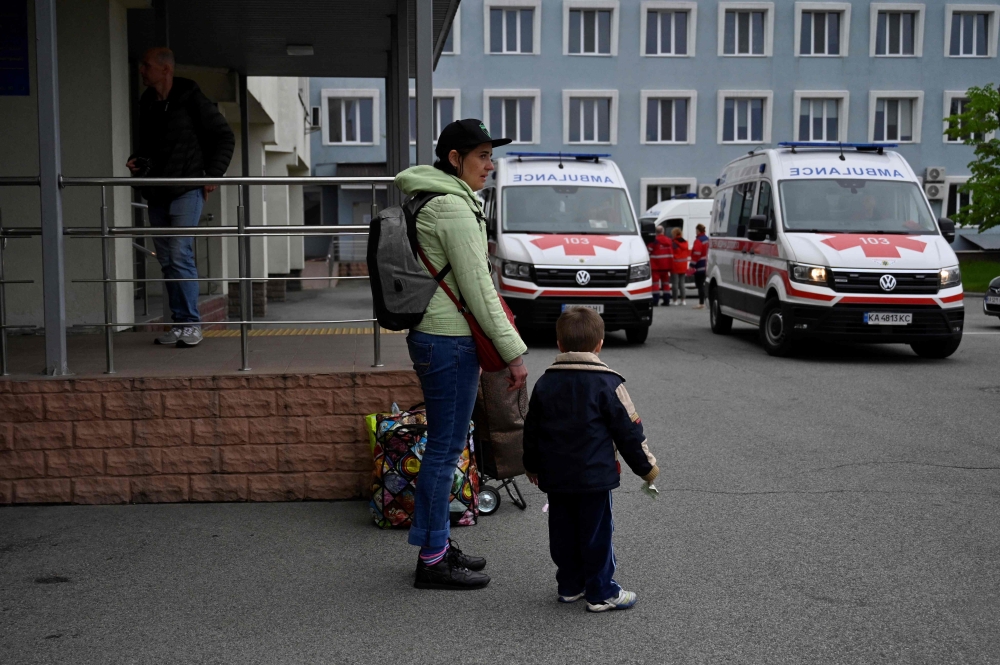 Relatives evacuate their children from childrens' hospital in Kyiv on April 26, 2024. Officials in Ukraine's capital Kyiv announced the evacuation of two hospitals on April 26, 2024, fearing they could be targeted by Russian strikes. (Photo by Sergei CHUZAVKOV / AFP)
