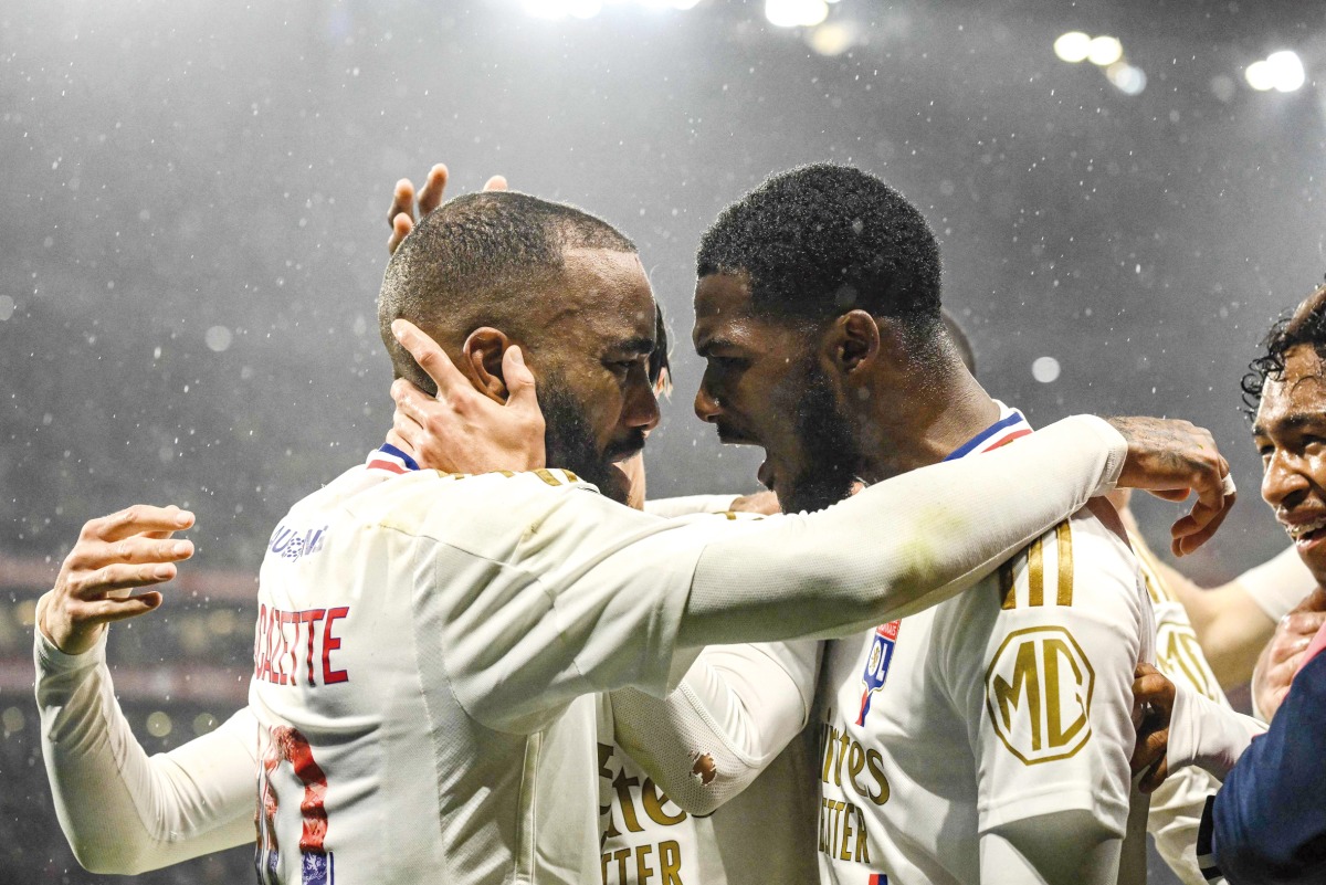 Lyon’s Clinton Mata (right) and Alexandre Lacazette celebrate a goal yesterday.
