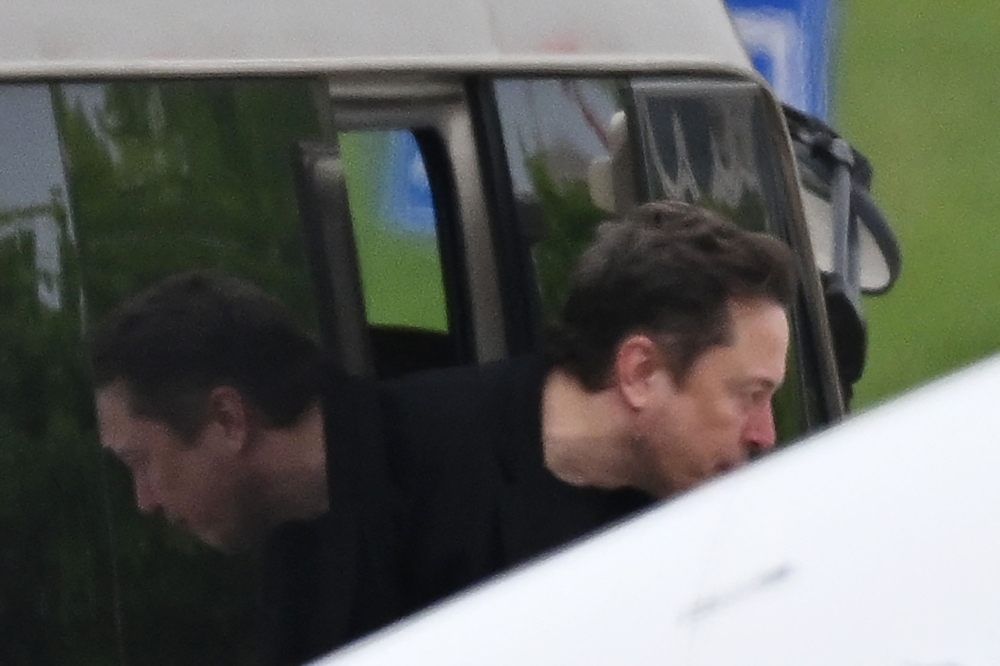 Tesla CEO Elon Musk gets off a minibus before boarding his private plane at Beijing airport on April 29, 2024. (Photo by GREG BAKER / AFP)

