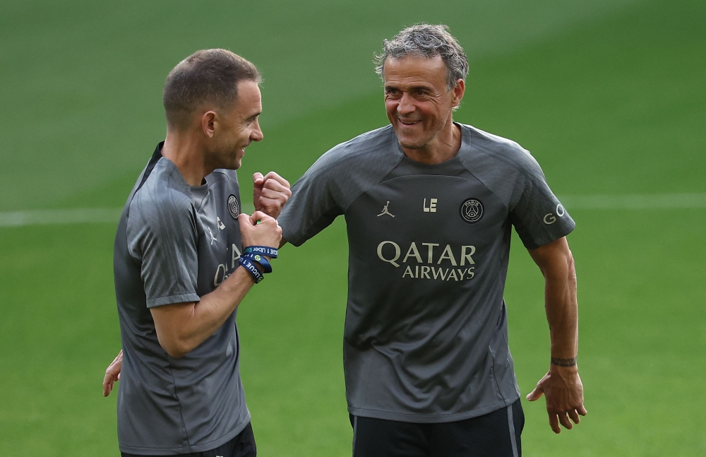 Paris Saint-Germain's Spanish head coach Luis Enrique (R) speaks with a staff member during a training session on the eve of their UEFA Champions League semi-final first leg football match against Borussia Bortmund at the Signal Iduna Stadium in Dortmund, western Germany on April 30, 2024. (Photo by FRANCK FIFE / AFP)