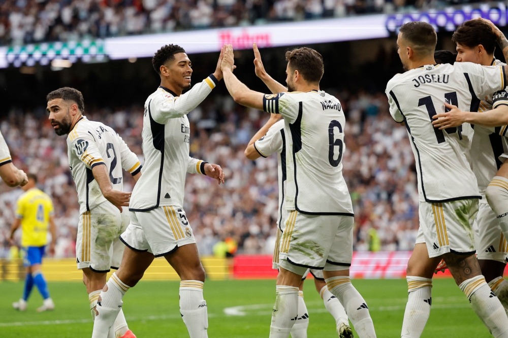 Real Madrid's English midfielder #5 Jude Bellingham celebrates scoring his team's second goal during the Spanish league football match between Real Madrid CF and Cadiz CF at the Santiago Bernabeu stadium in Madrid on May 4, 2024. (Photo by OSCAR DEL POZO / AFP)
