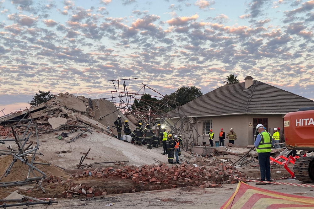 Rescue workers are seen at the scene of a collapsed building in George on May 7, 2024. (Photo by Willie van Tonder / AFP)
