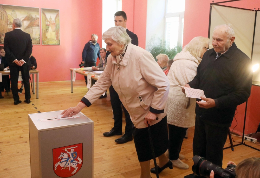 Voters arrive to cast their ballots during the first round of Lithuania's presidential election in front of a polling station in Vilnius on May 12, 2024. (Photo by PETRAS MALUKAS / AFP)
