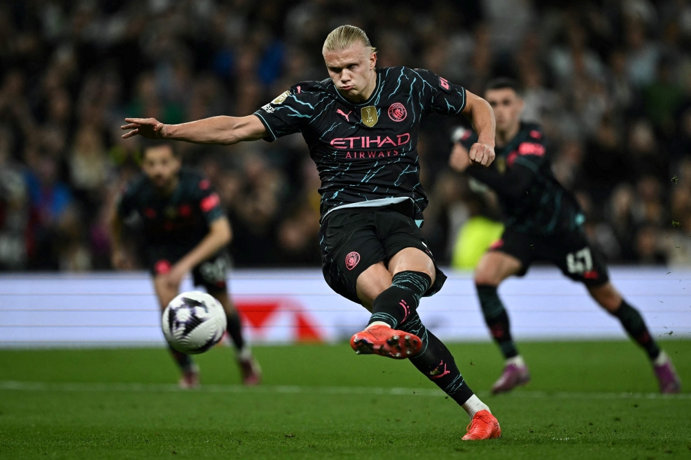Manchester City's Norwegian striker #09 Erling Haaland shoots a penalty kick and scores his team second goal during the English Premier League football match between Tottenham Hotspur and Manchester City at the Tottenham Hotspur Stadium in London, on May 14, 2024. (Photo by Ben Stansall / AFP) 