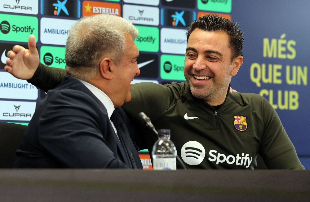 FC Barcelona President Joan Laporta (L) and Barcelona's Spanish coach Xavi react during a press conference in Sant Joan Despi, near Barcelona, on April 25, 2024. (Photo by Lluis Gene / AFP)