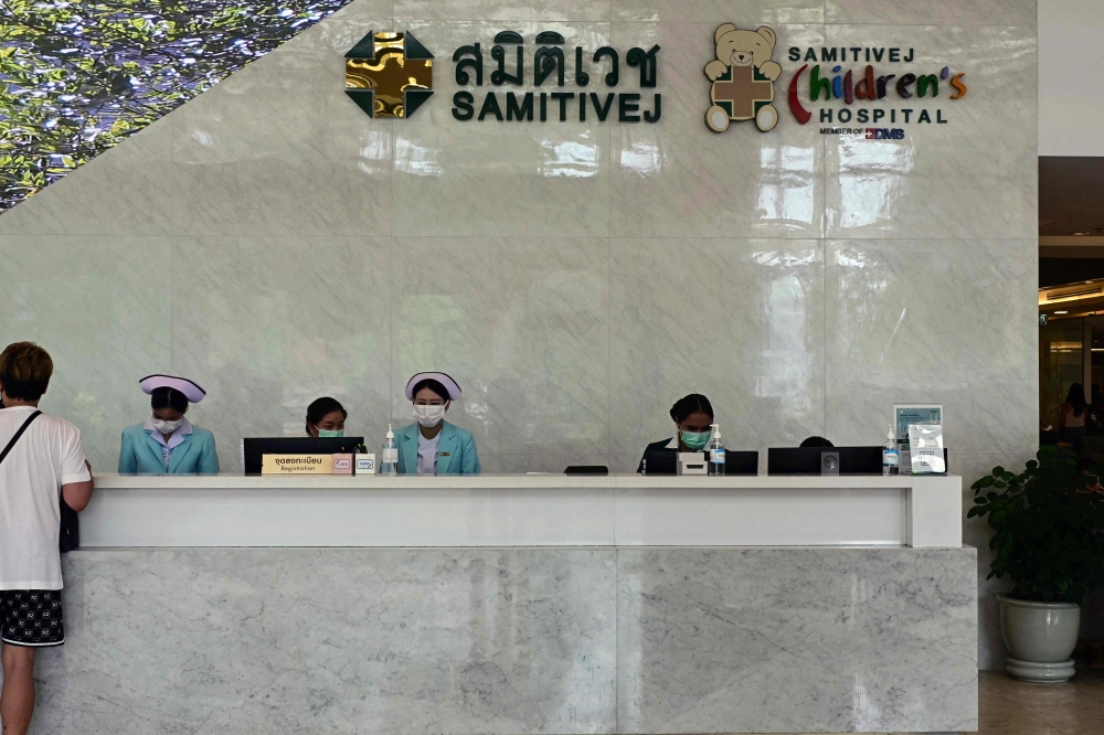 Hospital personnel work on a registration desk at Samitivej Srinakarin Hospital, where some of the injured passengers on a turbulence-hit Singapore Airlines flight were being treated, in Bangkok on May 22, 2024. Photo by MANAN VATSYAYANA / AFP