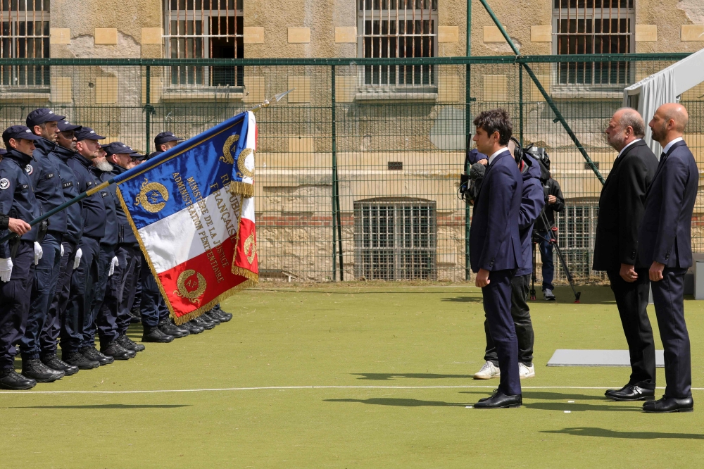 France's Prime Minister Gabriel Attal and France's Justice Minister Eric Dupond-Moretti face the prison guard units presenting the flag of France as they attend at the former prison in Caen, northwestern France, 22 May 2024. Photo by Teresa Suarez / POOL / AFP.