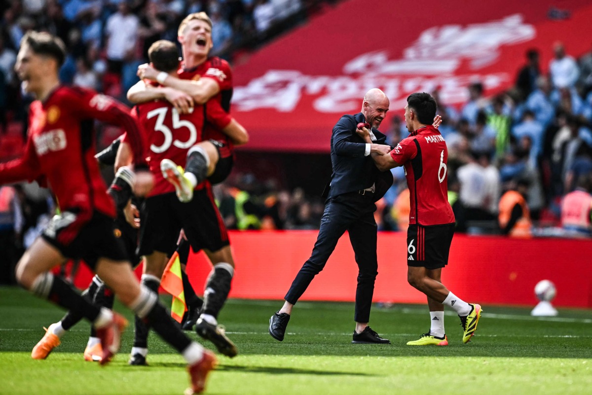 Manchester United's Dutch manager Erik ten Hag (C) celebrates with his players after winning the English FA Cup final football match between Manchester City and Manchester United at Wembley stadium, in London, on May 25, 2024. Manchester United wins 2 - 1 against Manchester City. (Photo by Ben Stansall / AFP)