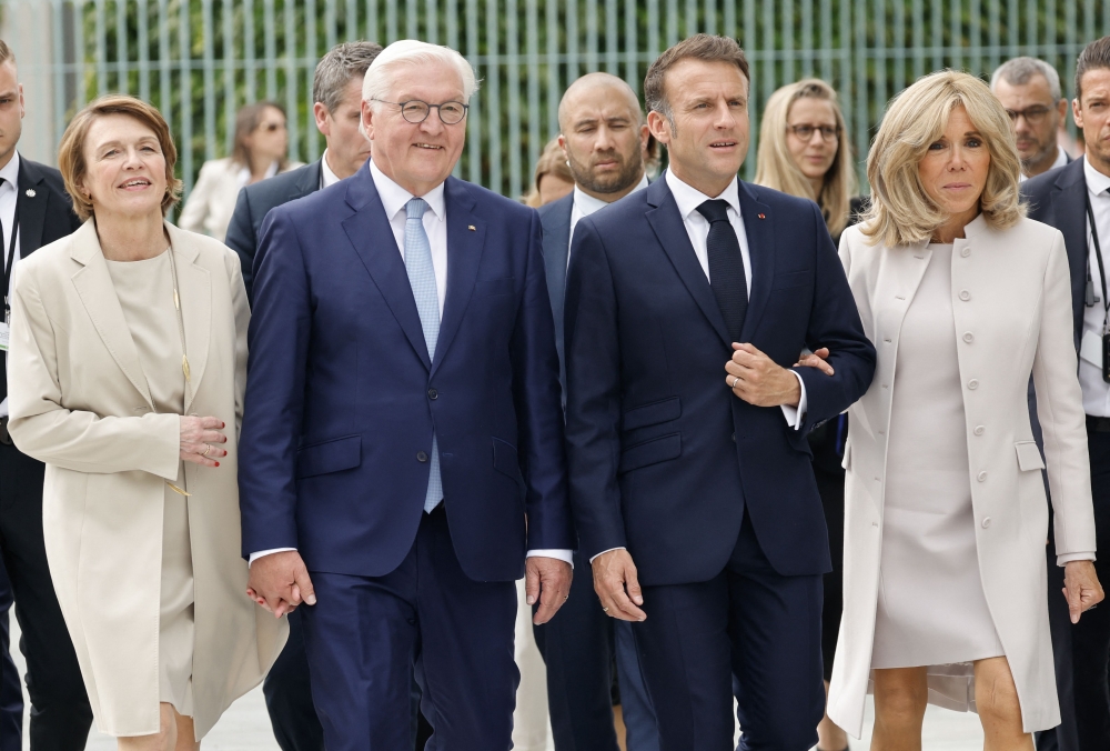 German President Frank-Walter Steinmeier (2ndL) and his wife Elke Buedenbender (L) walk with French President Emmanuel Macron (2ndR) and his wife Brigitte Macron (R) past the Chancellery on their way to attend a debate as part of the Festival of Democracy (Demokratiefest) on May 26, 2024 in Berlin. Photo by Ludovic MARIN / AFP.