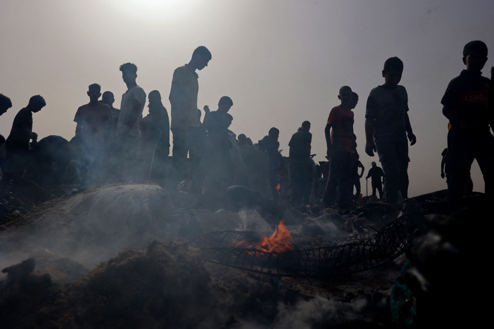 Palestinians gather at the site of an Israeli strike on a camp for internally displaced people in Rafah on May 27, 2024. (Photo by Eyad Baba / AFP)

