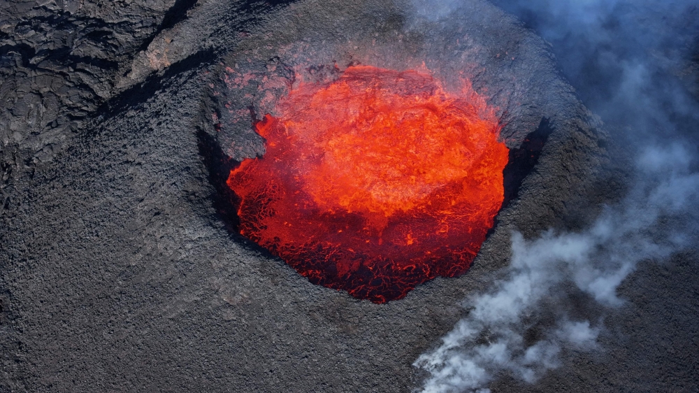 Picture taken with a drone on April 13, 2024 at Svartsengi near Grindavik, Iceland, shows an aerial view of a volcanic eruption at Sundhnukagigar in southwest Iceland, ongoing for a month. Photo by Jeremie RICHARD / AFP