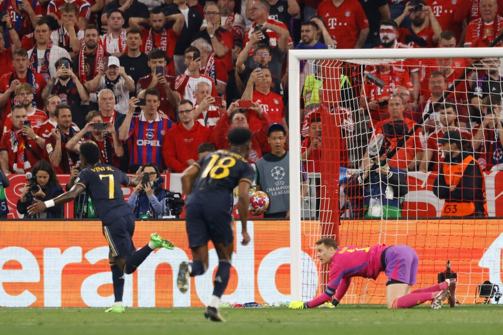 Real Madrid's Brazilian forward #07 Vinicius Junior (L) celebrates scoring the 2-2 goal from the penalty spot past Bayern Munich's German goalkeeper #01 Manuel Neuer during the UEFA Champions League semi-final first leg football match between FC Bayern Munich and Real Madrid CF on April 30, 2024 in Munich, southern Germany. (Photo by Michaela STACHE / AFP)


